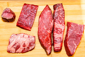 A lot of different steaks of marbled beef lies on the Board, rib eye, tenderloin, Striploin, machete, diaphragm.