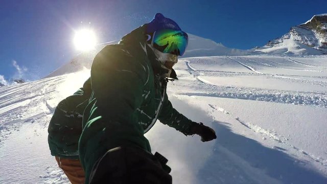 GoPro shot held by a pro snowboarder going down a powdery hillside