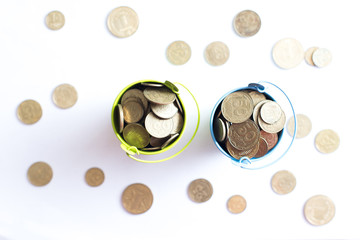 A bucket with coins on a white background is isolate. Business concept