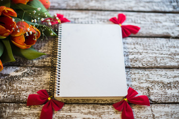 Tulips on a wooden old background and notebook