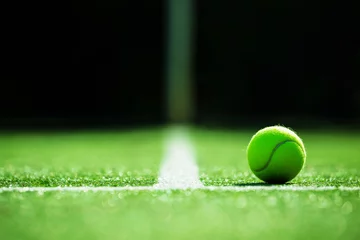 Tuinposter soft focus of tennis ball on tennis grass court © kireewongfoto