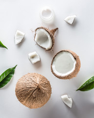 Homemade coconut cosmetic with coconut and green leaf on white background. from top view