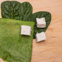 green pancakes with spinach leaves and cheese