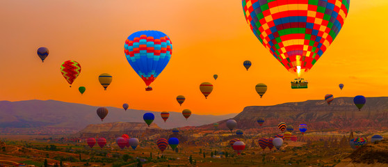 Hot air balloons sunrise landing in a mountain