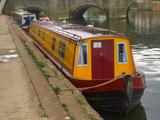 Fototapeta na wymiar River view of the river avon with mooring narrowboats in Tewkesbury in Gloucestershire, Great Britain.