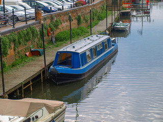 Fototapeta na wymiar River view with amooring narrowboat in Tewkesbury in Gloucestershire, Great Britain.