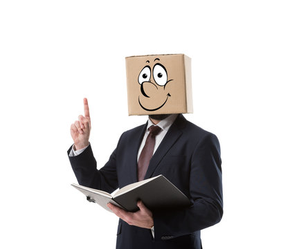 businessman with cardboard box on head holding folder and pointing up with finger isolated on white