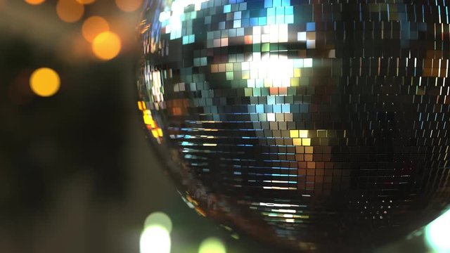 Turning mirror disco ball against bokeh background. Joy, dancing or party concepts
