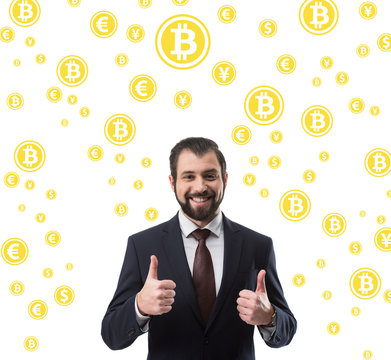 bearded smiling businessman in suit showing thumbs up, bitcoin and money symbols isolated on white