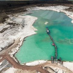 Aerial view of the long boom of a suction excavator in a quartz quarry for the excavation of white...