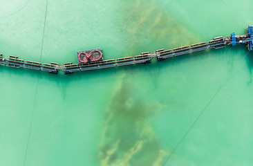 Aerial view of the long boom of a suction excavator in a quartz quarry for the excavation of white sand.