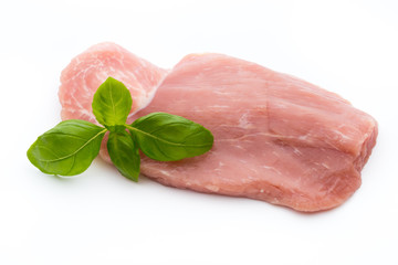 Fresh pork fillet with basil on a white background.