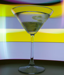 A martini glass with a cocktail in beautiful light of different colors