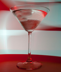 A martini glass with a cocktail in beautiful light of different colors