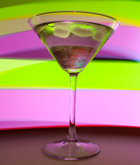 A martini glass with a cocktail in beautiful light of different colors