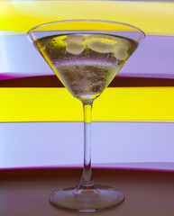 A martini glass with a cocktail in beautiful light of different colors