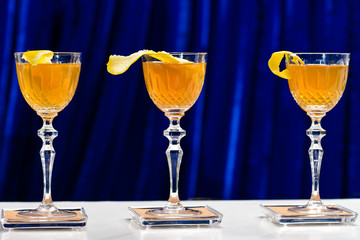 Three glasses with orange alcoholic cocktail at the bar counter