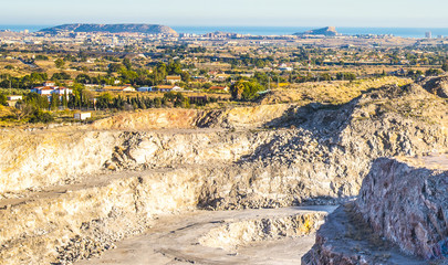 Exacavacion minera a cielo abierto con panoramita a la huerta de alicante y con el fondo el mar mediterraneo