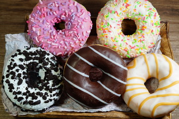 Colored delicious donuts . Glazed , colorful donuts on a table
