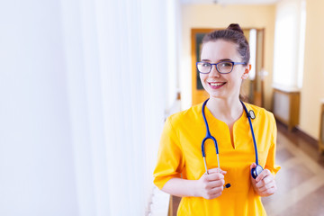 Portrait of cheerful happy doctor in hospital with stethoscope and glasses