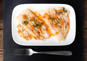 overhead take of fresh cod fillet cooked in classic wood
