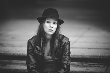 Woman with hat sitting outside and looking serious