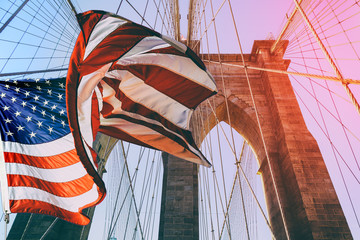 Obraz premium Flaga Stanów Zjednoczonych na górze Most Brookliński. Na tle jest głębokie błękitne niebo, na pierwszym planie są wszystkie przewody mostu. Koncepcja patriotyzmu.