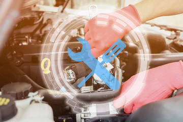 Cropped image of handsome young auto mechanic in uniform repairing car in auto service