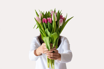 Spring bouquet of pink tulips in woman's hands