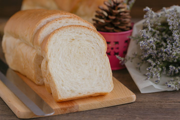 Sliced soft and sticky delicious white bread on wood cutting board prepare for breakfast on wooden table with close up view and copy space. Homemade bakery concept for family.