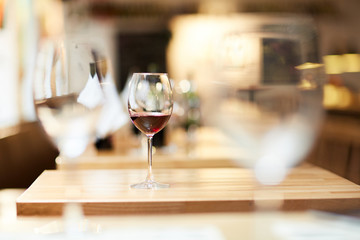 Selective focus of glass with red wine at restaurant