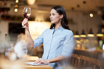 Female sommelier at work. She is tasting good red wine