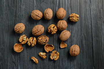 Walnut kernels and whole walnuts on rustic old wooden table