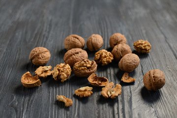 Walnut kernels and whole walnuts on rustic old wooden table