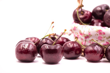Cherry spread on white blackground,some put in handmade wooden basket. Tell take care your health.