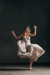 Young beautiful female dancer is posing in the studio