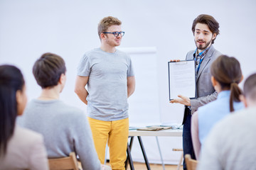 Fototapeta premium Two young confident businessmen presenting their financial project to audience at conference