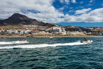 Foto op Canvas Motorboot varen voor de westkust van Tenerife, een van de vele vrijetijdsactiviteiten die worden aangeboden aan toeristen op de Canarische Eilanden. De diepblauwe wateren in contrast met een levendig landschap zorgen voor een ontspannende omgeving. © Bartkowski