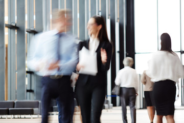 Blurred motion of two business people discussing papers on the move