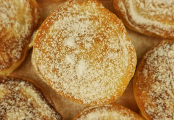 Fritters with powdered sugar on the beige dish