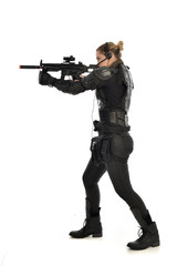 full length portrait of female  soldier wearing black  tactical armour, standing  with back to the camera holding a gun, isolated on white studio background.