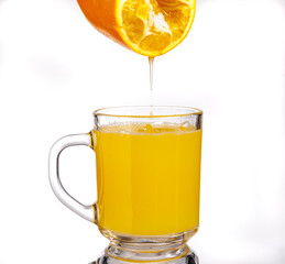Orange juice drips into a glass of orange juice.Isolated on a white background.