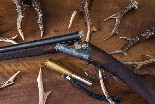 Beautiful hunting rifle and deer antlers on wooden background