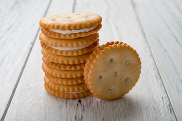 sandwich biscuits with white cream filling on white wood background