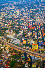 The view of Chiang Mai metropolis in Thailand from the sky with buildings and nature in the afternoon of sunny day. 