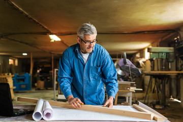 middle aged wood engineer working in his workshop