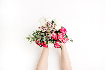 Female hands hold wedding flowers bouquet with roses, eucalyptus branch, wildflowers. Flat lay, top view bridal background.