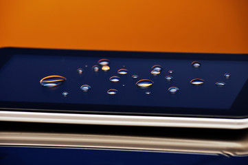 Drops of water on the smartphone screen. A saturated bright colored background. Copy space. close-up