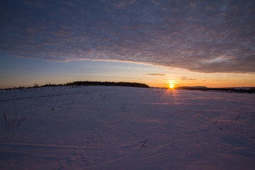 sunset in the winter frosty evening in the Russian outback