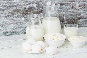 Different dairy products, white wooden background